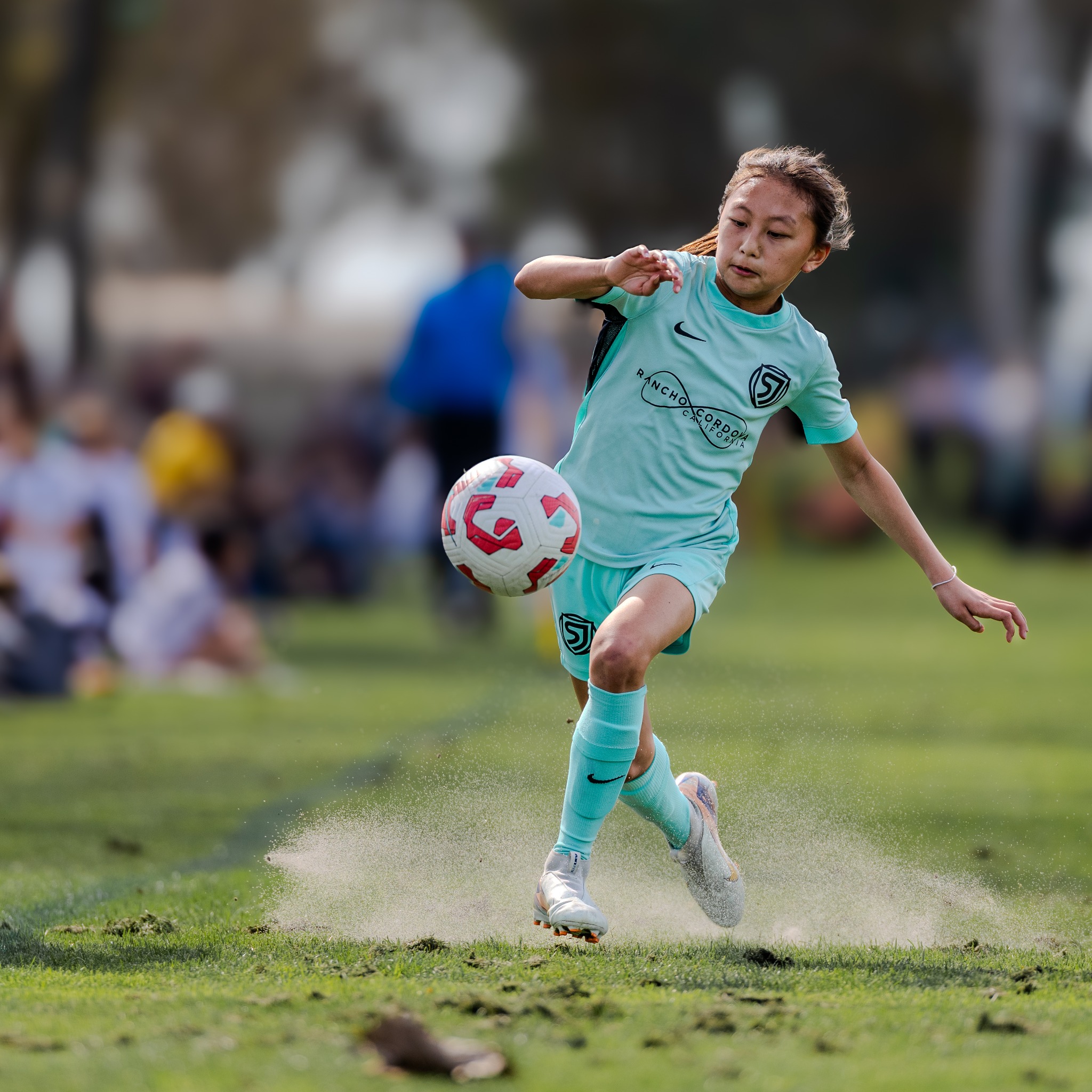 Youth soccer player controlling the ball on a grass field