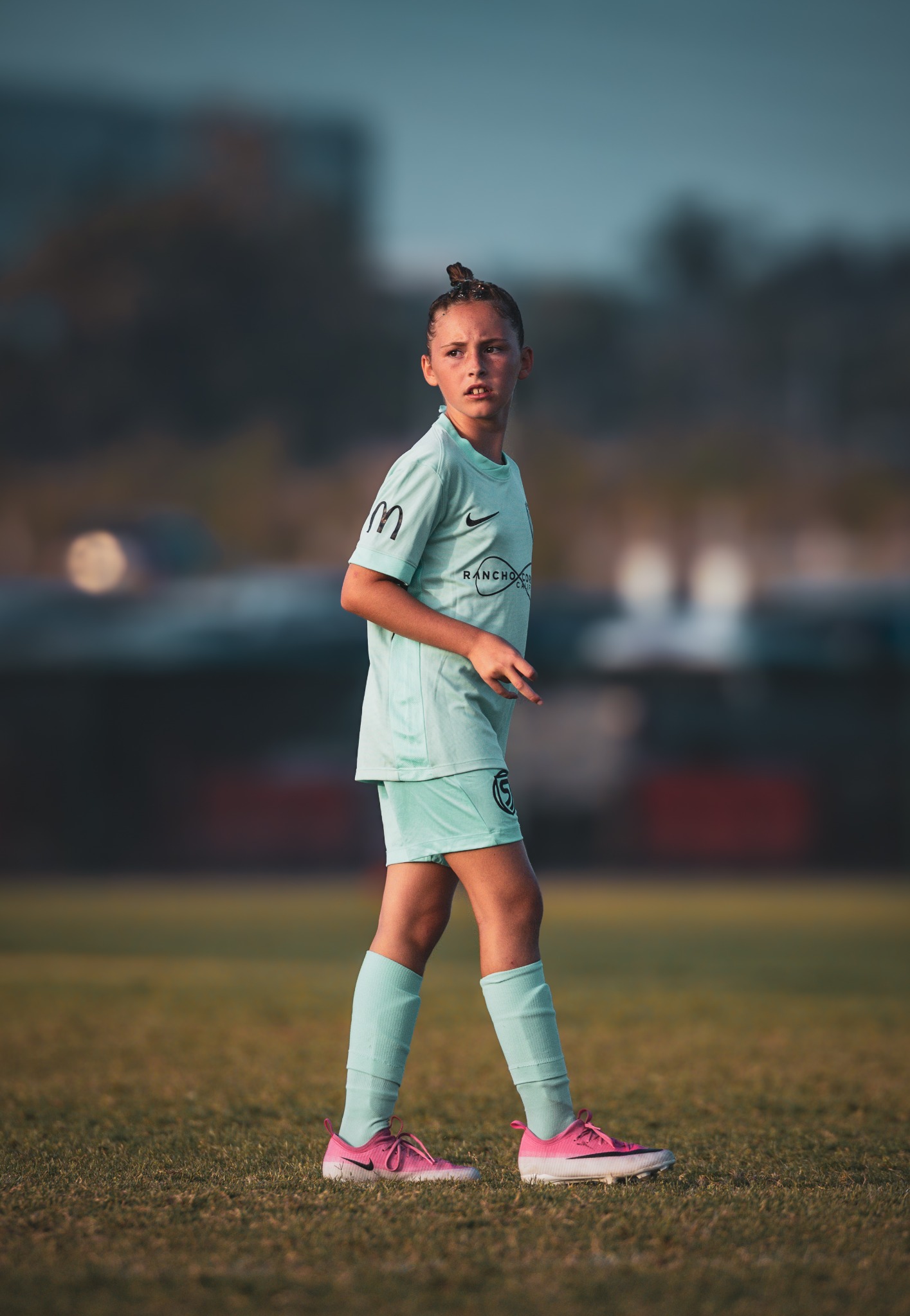 Youth soccer player watching the field in warm evening light