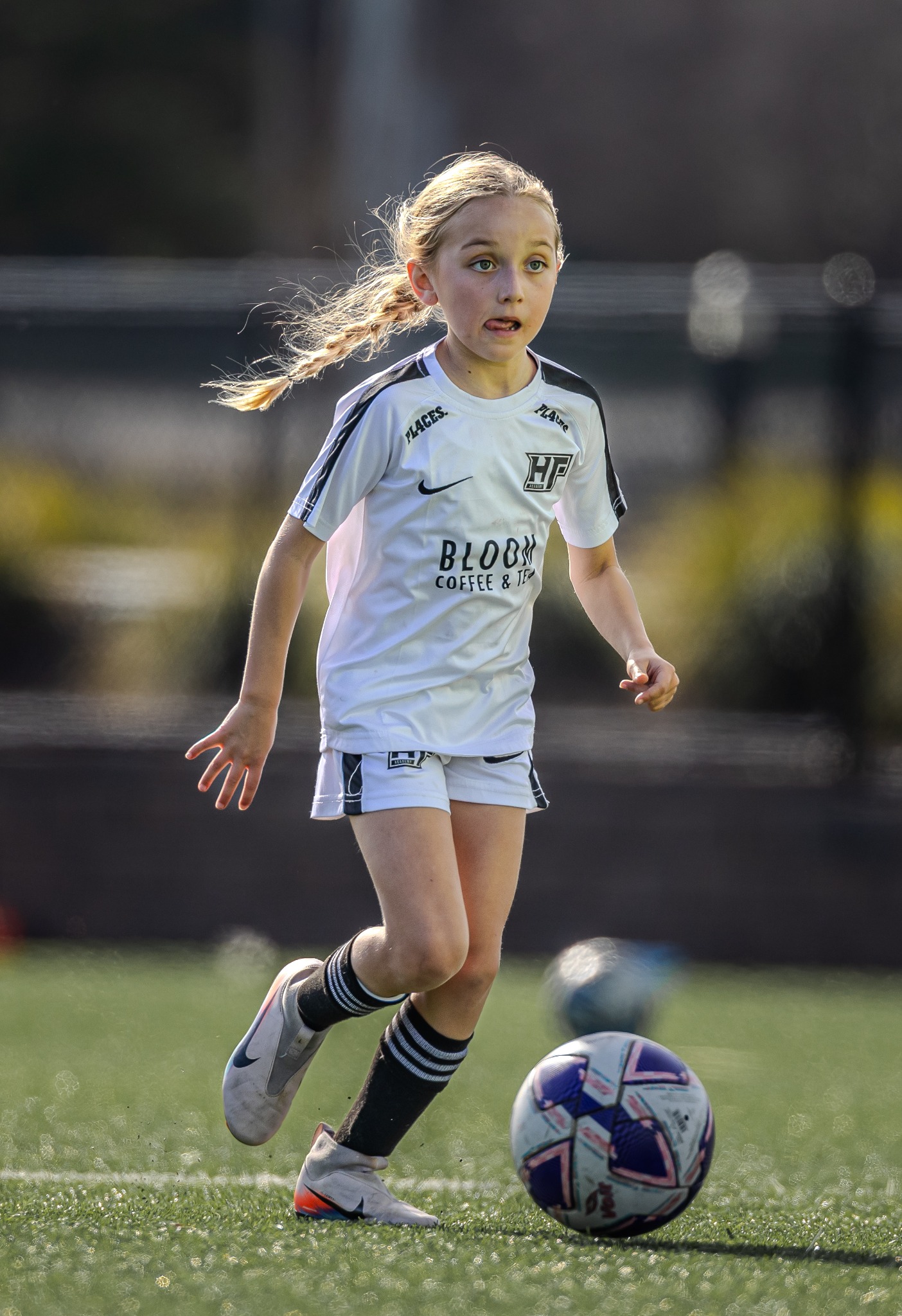 Youth soccer player dribbling in backlight